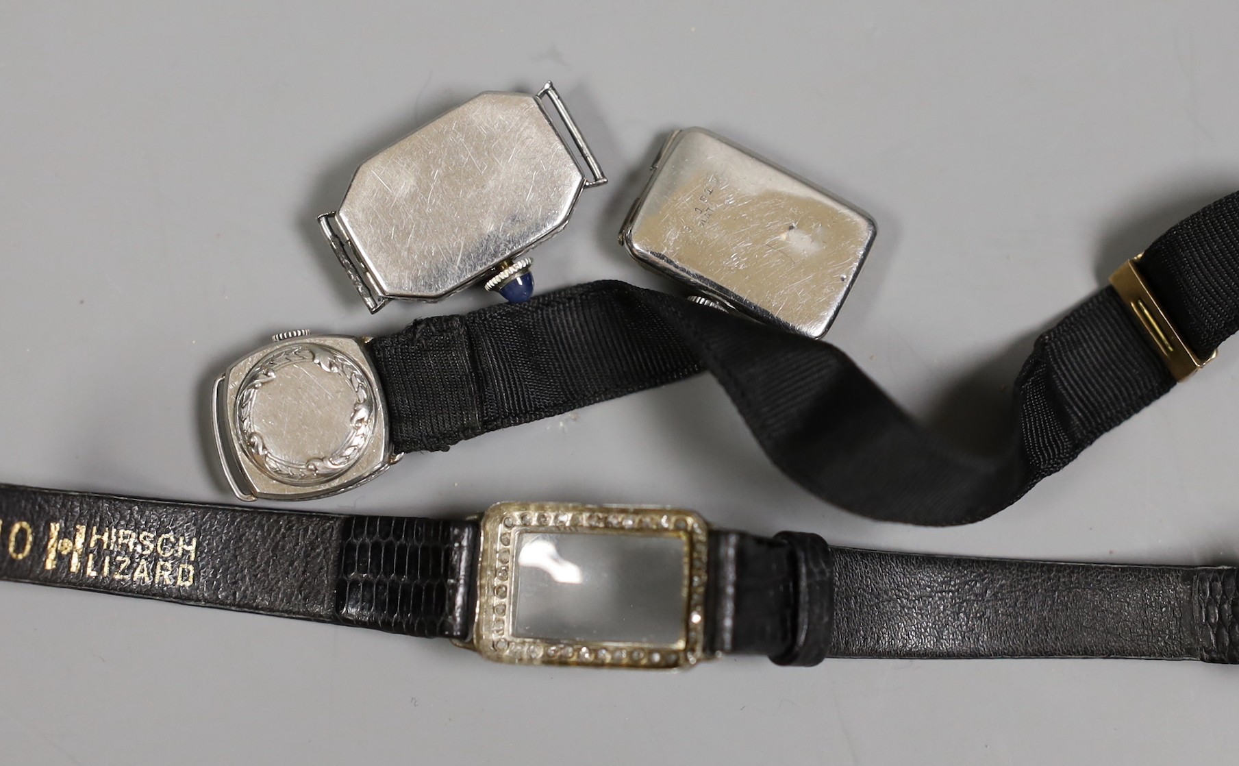 Three assorted mid 20th century white metal and diamond set manual wind cocktail watches, one stamped platinum, (a.f.).